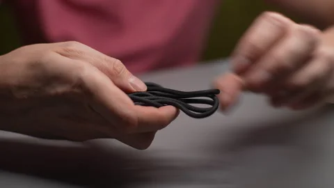 Closeup of unrecognizable man meticulously untangling usb cable, preparing it Stock Footage 297631604