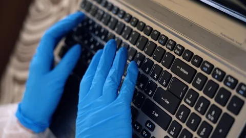 Closeup unrecognizable medic in blue protective gloves remote work on laptop. Stock Footage 128553843