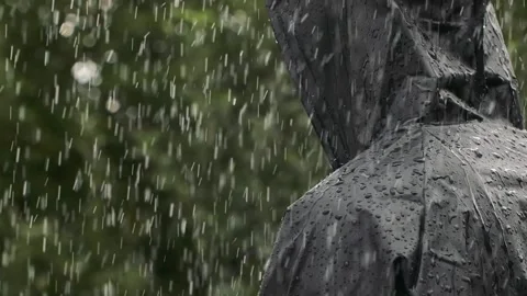 Closeup unrecognizable person in heavy rain, young man in water proof black coat Video stock 257170132