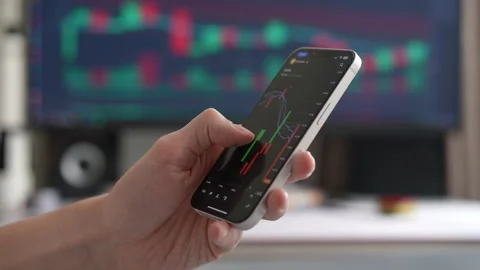Closeup of unrecognizable trader using mobile phone to analyze stock market data Stock Footage 297626147