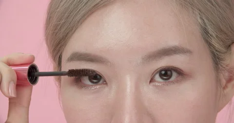 Closeup of upper half of Asian woman's face applying mascara for eyelashes. Stock Footage 206106569