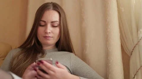 Closeup of use while relaxing on a sofa mobile phone : social networks , the Stock Footage 60584407