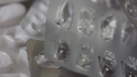Closeup of used empty blisters of pills rotating in a seamless loop Stock Footage 286218994