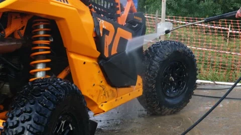 Closeup UTV buggy vehicle washed by anonymous person with high pressure water. Stock Footage 189060647