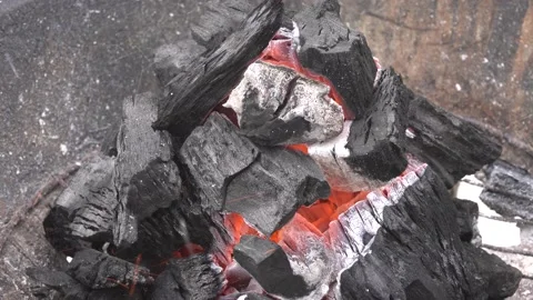 Closeup of various coals on a grill burning red hot and ashes flying everywhere Stock Footage 155810492