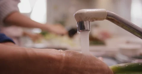 Closeup of vegetables being washed clean in white sink faucet Stock Footage 123788399