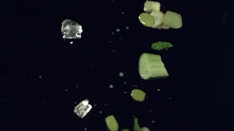 Closeup of vegetables fruit and ice falling across screen in slow motion H Stock Footage 109573595