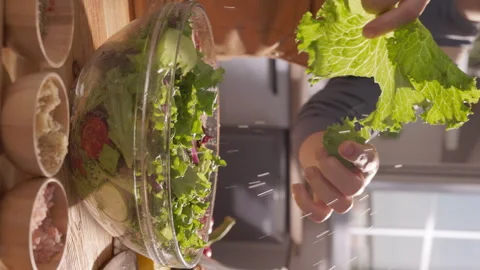Closeup Vertical shot of a Cook Adding Fresh Vegetables to a Mediterranean Salad Stock Footage 294961632