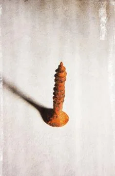 Closeup vertical shot of rusty weathered screw with grunge effect Stock Photos