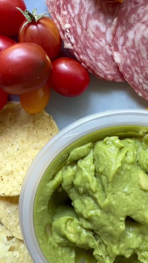 Closeup vertical view of salami, cheese and guacamole meal Stock Footage 247663197