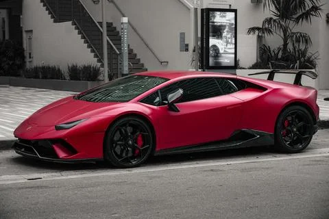 Closeup of a vibrant Lamborghini Huracan Tecnica parked on the side of street in Stock Photos