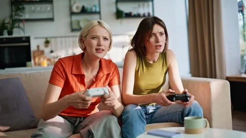 Closeup video gaming girlfriends having fun sitting sofa. Besties game fail Stock Footage 335162224