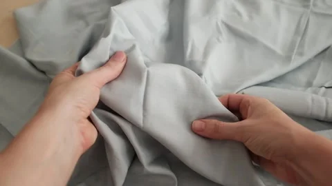 Closeup video of hands touching soft blue silk fabric. Video stock 317094091