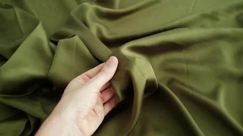 Closeup video of hands touching soft green silk fabric Stock Footage 317094151