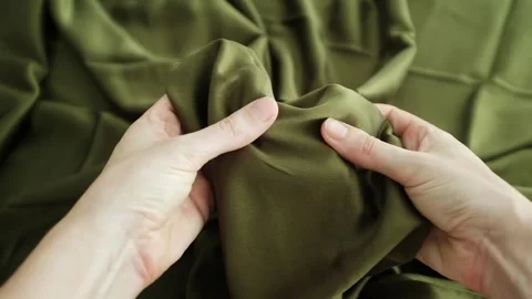 Closeup video of hands touching soft green silk fabric Stock Footage 317094208