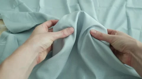 Closeup video of hands touching soft blue silk fabric. Video stock 317094226