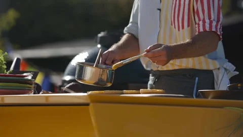 Closeup video of a man behind kitchen table, applying the butter on burger buns Stock Footage 247054641