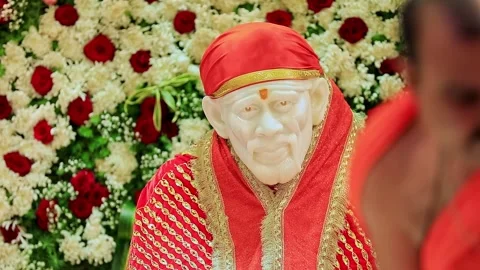 A closeup video of Sai Baba or Sai Ram idol surrounded by floral decoration.. Stock Footage 328011456