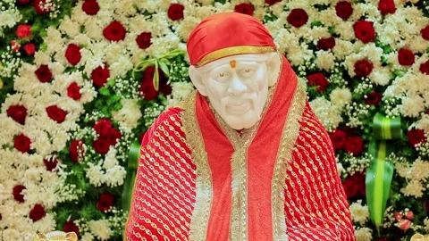 A closeup video of Sai Baba or Sai Ram idol surrounded by floral decoration.. Video stock 328011457