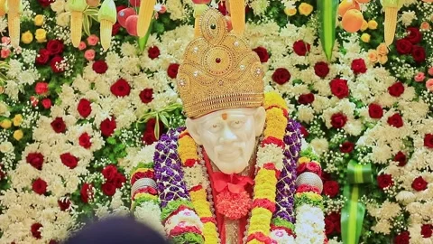 A closeup video of Sai Baba or Sai Ram idol surrounded by floral decoration.. Video stock 328011458
