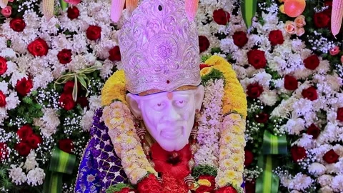 A closeup video of Sai Baba or Sai Ram idol surrounded by floral decoration.. Video stock 328011604