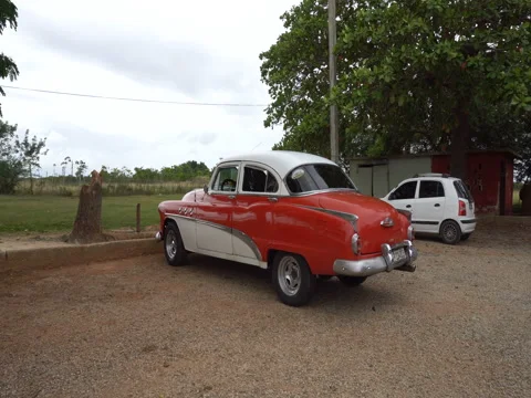 Closeup view around red retro car in the parking lot of local cuban villa Stock Footage 71533968
