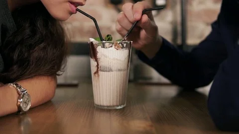 Closeup view of attractive young couple in cafe sitting at the wooden table and Stock Footage