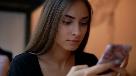 Closeup view of attractive young lady with natural makeup using her mobile phone Stock Footage 79527916