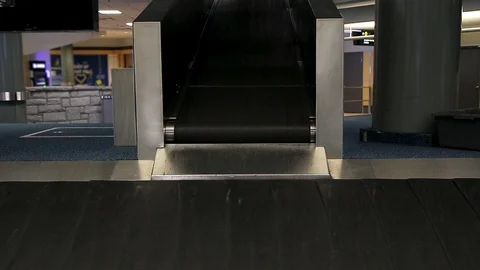 Closeup view of a baggage carousel and a bag passing by in the arrivals area of Видео 123827613