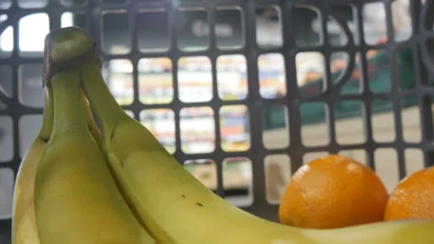 Closeup view of bananas and oranges inside the fast moving shopping cart in the Video stock 111474337