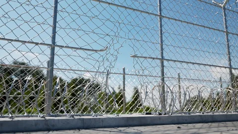 Closeup view at the broken fence of prison. Escape. Barbed wires. Freedom. 4k HD Video stock 126266357