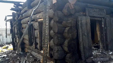 Closeup view of burned-down wooden house in the village, abandoned as a result Stock Footage 100588626