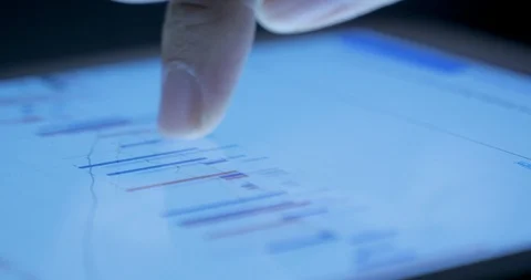 Closeup view of a businessperson's finger analyzing stock market graph on a d Stock Footage 95626010
