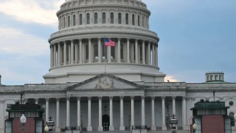 Closeup view of Capital Hill building with waving United States of America flag Stock Footage 294554577