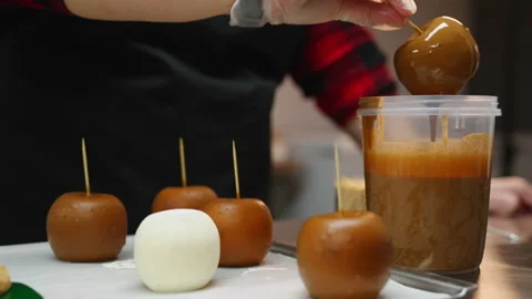 Closeup view of the chef's hand with gloves holding an apple with a stick and Stock Footage 230111487
