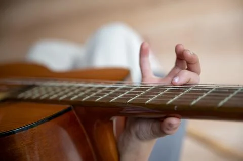 Closeup view of a child practicing playing guitar Stock Photos