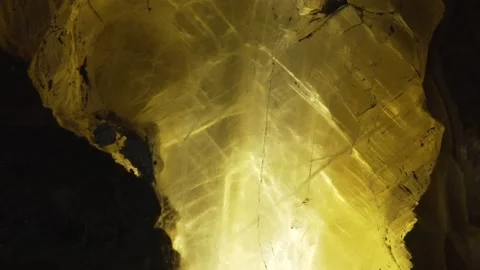 Closeup view of a chunk of an yellow crystal located in a dark cave. Stock Footage 132961990