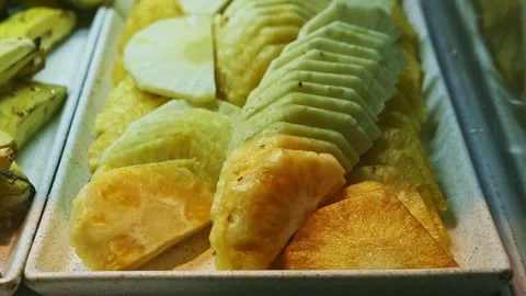 Closeup view on cleaned tropical pineaple slices at food court assortment Stock Footage 144394192