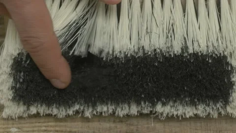 A closeup view of a cleaning brush surrounded by dust and various types of Stockbeeldmateriaal 281328418