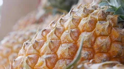 Closeup view of clustered pineapples stacked together at a fruit stand, their Video stock 308870647