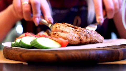 Closeup view of cooked tasty red grill meat with sliced vegetables on wooden rou 스톡 동영상 117668189