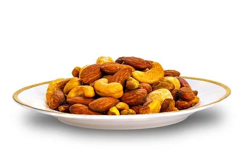 Closeup view of crispy salted mixed nuts in white ceramic dish. Stock Photos