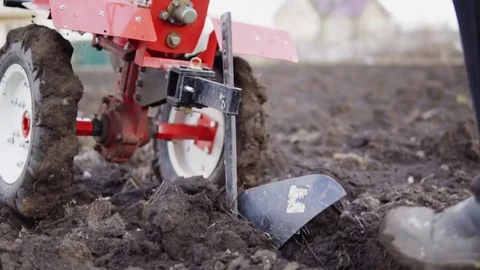 Closeup view of a cultivator tiller preparing garden soil, new seeding season on Stock Footage
