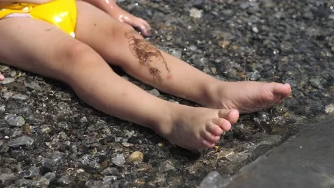 Closeup view of cute 2 years old boys legs in yellow swimming trunks, sitting Stock Footage 219594118