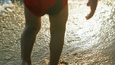 Closeup view of cute small legs of little child in sparkling blue sea water 4k Stock Footage 107768494