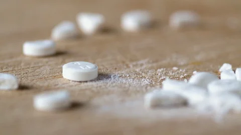 Closeup view cutting white round pill by knife on wooden board Vídeos de archivo 99786756