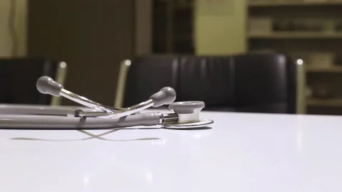 Closeup view of doctor taking stethoscope from the doctors table Stock Footage 132424463