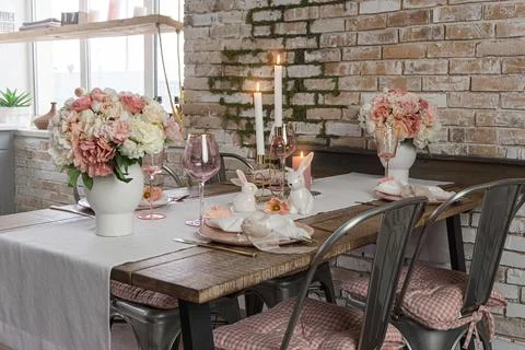 Closeup view of dreamy cute table decor with glasses flowers and lit candles. Stock Photos