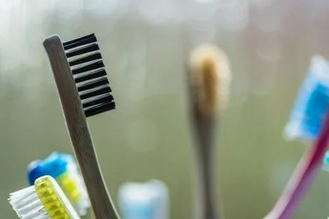 Closeup view of eco-friendly bamboo toothbrush next to window in bathroom Foto stock