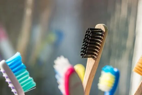 Closeup view of eco-friendly bamboo toothbrush next to window in bathroom 库存照片